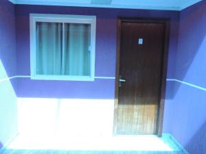 a blue room with a door and a window at Pousada Centaurus in Alto Paraíso de Goiás