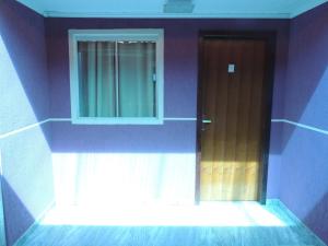 a purple room with a door and a window at Pousada Centaurus in Alto Paraíso de Goiás