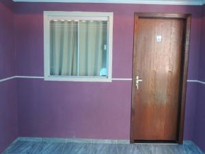 a door in a room with a purple wall at Pousada Centaurus in Alto Paraíso de Goiás