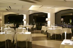 jadalnia z białymi stołami i krzesłami w obiekcie Eolian Milazzo Hotel w mieście Milazzo