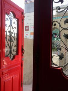 a red door with a mirror next to a building at Angel Wings Inn in Hualien City