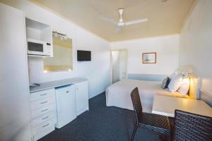 a bedroom with a bed and a table and chairs at Boulevard Motel in Stanthorpe