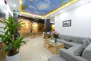 a living room with a couch and tables and a ceiling at Blue Hanoi Inn City Hotel in Hanoi