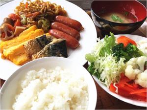 una mesa con dos platos de comida con arroz y verduras en Hotel Sun Queen, en Naha