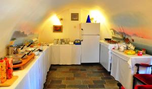 a kitchen with white counters and a white refrigerator at Margarita Hotel in Kythira