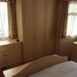 - une chambre avec des placards blancs, un lit et une fenêtre dans l'établissement Poppy's Retreat, à Bréville
