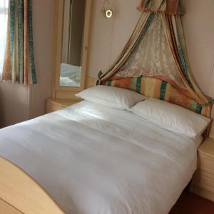 - une chambre avec un lit blanc à baldaquin dans l'établissement Poppy's Retreat, à Bréville