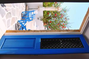 a blue window with a plant in the background at Margarita Hotel in Kythira