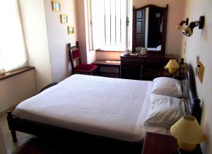 a bedroom with a bed and a desk and a window at Margarita Hotel in Kythira