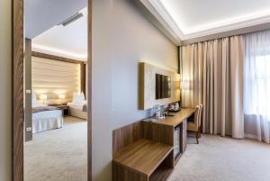 ein Hotelzimmer mit einem Schreibtisch und einem Bett in der Unterkunft Hotel Elektor Premium in Krakau