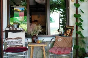 a porch with two chairs and a table and a window at Hikers Hostel in Veliko Tŭrnovo