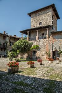 a large stone building with flowers in front of it at La Torre Medioevale in Marne di Filago