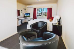 a hotel room with a bed and two chairs at Boulevard Motel in Stanthorpe