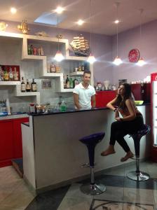 a man and a woman sitting at a bar at Hotel Jonic in Portopalo