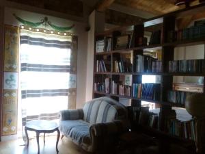 salon z krzesłem i półką z książkami w obiekcie Antico Casale dei Sogni agriturismo w mieście Lugo