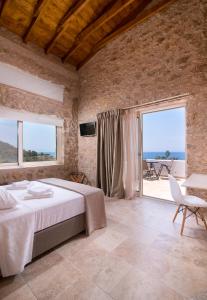 a bedroom with a bed and a view of the ocean at Mare Pedra Villas in Skala Marion
