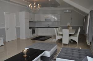 a kitchen with a table and a dining room at Apartments Royal Menex in Požarevac