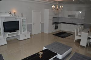 a living room with a television and a dining room at Apartments Royal Menex in Požarevac