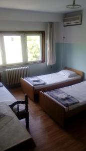 Zimmer mit 3 Betten und 2 Fenstern in der Unterkunft Hostel Mlin Balkan in Skopje