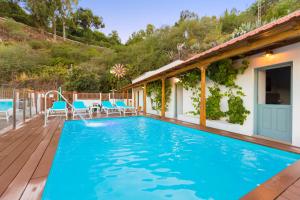 a swimming pool with chairs and a house at Villa Mica in Vega de San Mateo