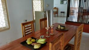 a wooden table with a plate of fruit on it at Allens home stay in Jaffna