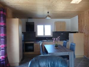 a kitchen with a wooden table and chairs and a table and a kitchen with at Gite chez Jean-Michel in Espinasse