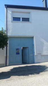 un garaje con una puerta de garaje azul en un edificio en Opatment, en Mörbisch am See