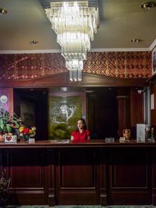 Una donna in piedi dietro un bar in un ristorante di Vienni a Orestias