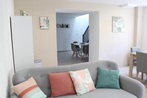 - un salon avec un canapé gris et des oreillers colorés dans l'établissement L'Annexe du Clos d'Esquay, à Esquay-sur-Seulles