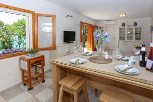 een keuken met een eiland met een tafel en stoelen bij Secret Garden Barada Beach Apartment in Trogir