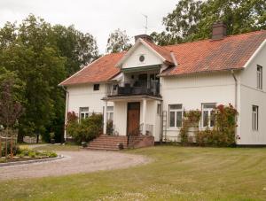 uma casa branca com um telhado vermelho em Ekeby i Bro em Bro