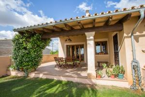 un patio con mesa y sillas bajo una pérgola en Carles, en Vilafranca de Bonany