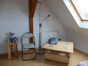um quarto com uma mesa e uma cadeira num sótão em Haus Peters em Stadtoldendorf