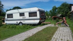 Una caravana estacionada en el césped junto a una estatua en Summer bungalo trailer, en Jūrmala