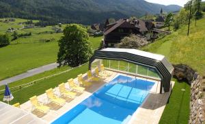 an overhead view of a swimming pool with chairs and a house at Hotel Restaurant Stigenwirth in Krakauebene