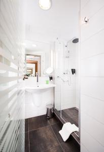 a white bathroom with a sink and a shower at Royal Park Boutique Hotel in Budapest