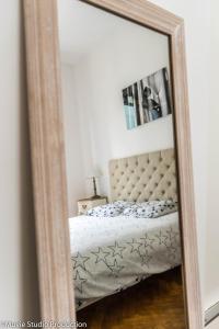 um espelho que reflecte uma cama num quarto em Charming Haussmannien 50m2 - city center em Rouen
