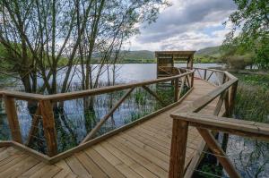a wooden bridge over a body of water at Casa do Eiró in Lago de Carucedo