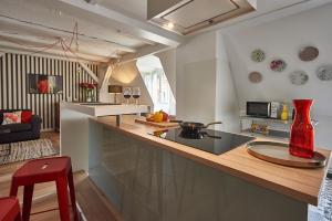 Una cocina con un jarrón rojo sobre una encimera. en Les Appartements Saint-Martin, en Colmar