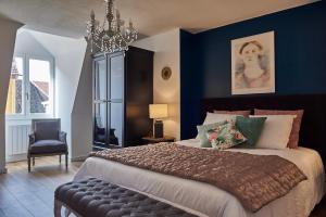 Un dormitorio con una cama grande y una lámpara de araña. en Les Appartements Saint-Martin, en Colmar
