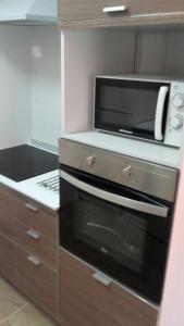 a kitchen with a microwave and a stove at Apartamento Sofia in Valencia
