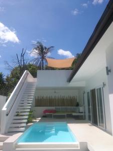 une maison avec une piscine à côté d'un escalier dans l'établissement Chuan Chom Villas, à Lamai