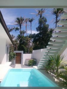 - une piscine à côté d'un bâtiment blanc avec des escaliers dans l'établissement Chuan Chom Villas, à Lamai
