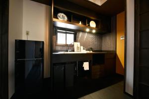 kuchnia z czarną lodówką i oknem w obiekcie Shibashi Umeyacho w mieście Kioto