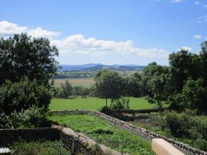 un jardín con una pared de piedra en un campo en Gite La Tourterelle, en Le Brignon