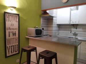 a kitchen with a counter with two stools and a microwave at Summer Home in Armação de Pêra