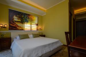 Un dormitorio con una cama blanca y una pintura en la pared en Bella & Stella rooms, en Buje