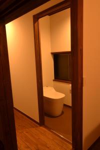 a bathroom with a toilet and a mirror at ILHA / ACCOMMODATION in Arita