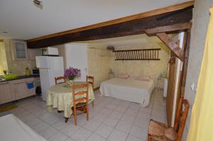 eine Küche mit einem Tisch und einem Bett in einem Zimmer in der Unterkunft Gite en Berry in Moulins-sur-Céphons