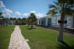 un chemin en pierre en face d'une maison avec un palmier dans l'établissement Reveli Estate, à Kalathas